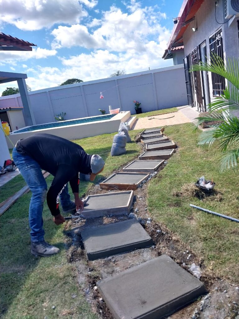 Jardinero fundiendo lajas de concreto para construir un camino de jardín